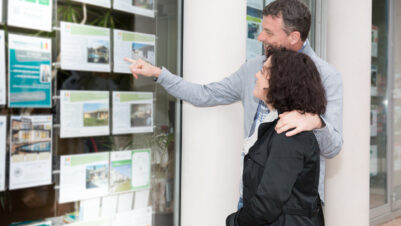 Stel bekijkt woningen in het aanbod bij een makelaarskantoor